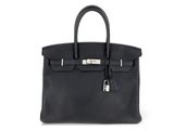 un sac à main en cuir noir sur fond blanc