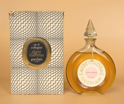 gros plan d'un flacon de parfum à côté d'une boîte