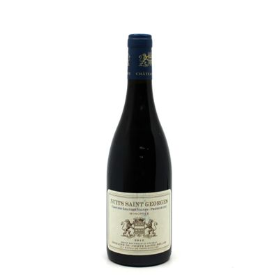 the bottle of red wine is sitting on a white surface