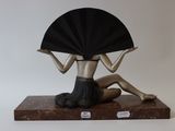 a statue of a woman with a fan sitting on a table