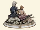 a figurine of a man and a woman sitting on a rock