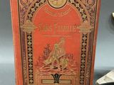 an old book sitting on top of a table next to a clock
