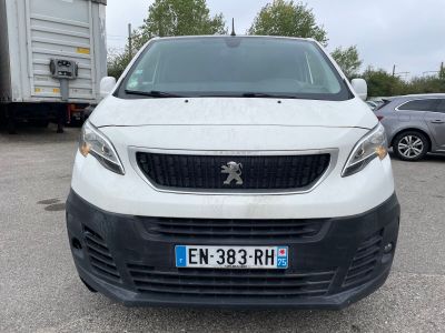 une camionnette blanche garée dans un parking avec d'autres voitures