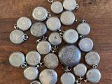 a close up of a bunch of metal buttons on a wooden surface