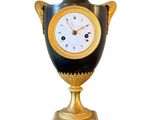 un vase noir et doré orné d'une horloge