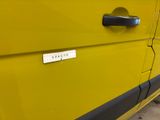 a close up of a yellow van with a sign on the door