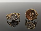 two gold and silver rings with diamonds on a black surface
