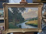une photo d'un tableau représentant une rivière, dans un cadre doré
