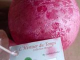une balle rouge à laquelle est attachée une étiquette, posée sur une table