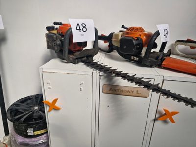 deux tronçonneuses posées sur une armoire