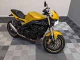 une moto jaune garée sur un sol à damier