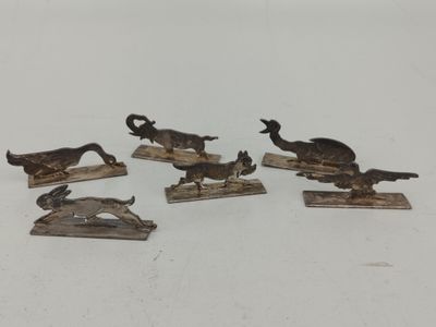 six figurines d'animaux en bronze posées sur des socles en bois, sur un fond blanc