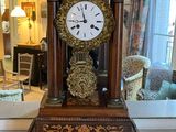 a clock that is sitting on a table in front of a mirror