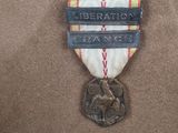 a medal with a ribbon around it that says liberation hang