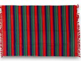 a red, green and blue striped rug with fringes