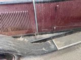a broken radiator on the ground next to a car