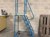 un chariot bleu sur lequel est posée une échelle, dans une pièce