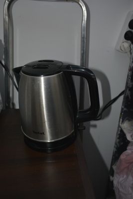 a kettle that is sitting on a shelf next to a bed