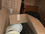a cardboard box full of dirty dishes and plates