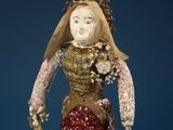 an old doll with a red dress and a white head
