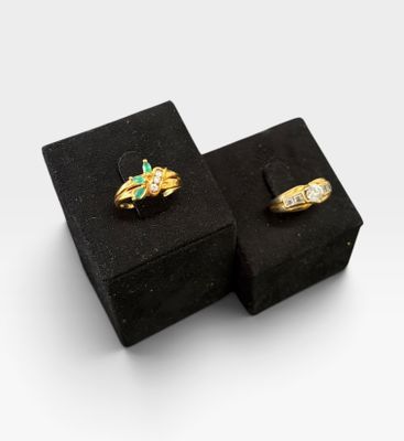 une paire de bagues en or et diamants présentées dans des coffrets en velours noir