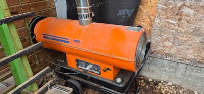 un chauffage au gaz de couleur orange posé dans un coin d'un immeuble