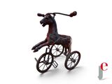 un cheval en peluche posé sur un tricycle