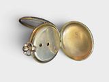 a silver pocket watch with a chain around it ' s neck