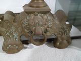 une statue en bronze représentant un lion surmontée d'une tête de lion