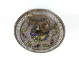 a silver plate with a bird on it on a white surface