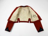 an old red and white jacket with writing on the sleeves