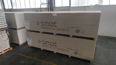 Deux palettes de cartons sont empilées sur des palettes dans un entrepôt