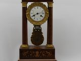 a clock that is sitting on top of a wooden stand