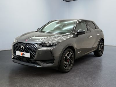 Une voiture grise est garée dans une pièce équipée d'un ventilateur de plafond.