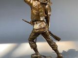 bronze statue of a soldier with a gun on a base