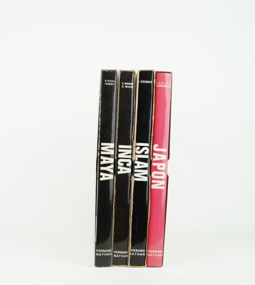 trois livres sont empilés sur une surface blanche