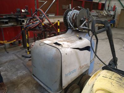 une machine qui se trouve dans un garage, à côté d'une fourche