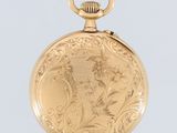 an antique gold pocket watch with a floral design on the front