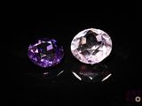 two purple and white gems sitting on top of a black surface