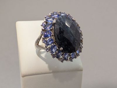 un gros plan d'une bague ornée d'une pierre entourée de saphirs bleus