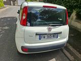 une petite voiture blanche garée sur le bord de la route