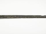 un gros plan d'une épée posée sur une surface blanche, ornée d'un anneau doré