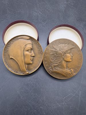 deux médailles d'or représentant les visages de deux femmes, dans un coffret