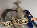 a belt with a gold buckle and a blue belt with a giraffe on it