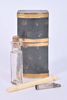 une petite bouteille en verre avec un bâtonnet en bois à côté