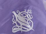 a close up of a purple robe with a white bird on it