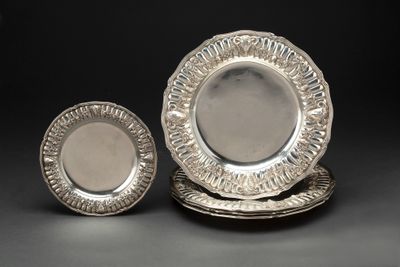 deux assiettes en argent et une assiette en argent sur fond noir