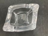 a clear glass ashtray on a black table