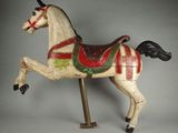 un cheval de bois recouvert d'une couverture rouge et verte sur le dos