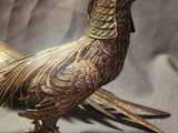 a metal bird that is standing on a table